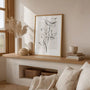 Linear branch line art poster styled in minimalist bedroom with neutral decor